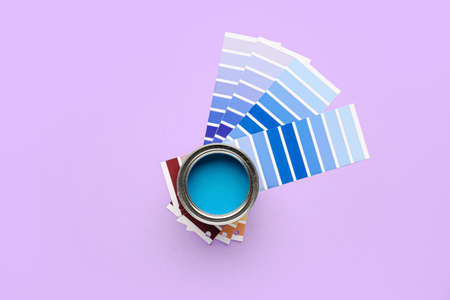 Can of blue paint with palette samples on color backgroundの写真素材
