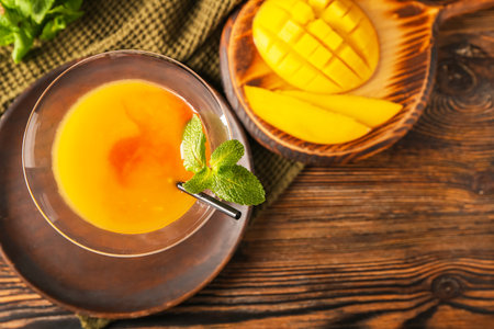 Glass of tasty mango margarita on wooden backgroundの写真素材