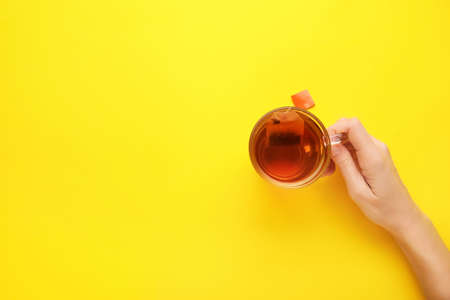 Woman with cup of tea on color backgroundの写真素材