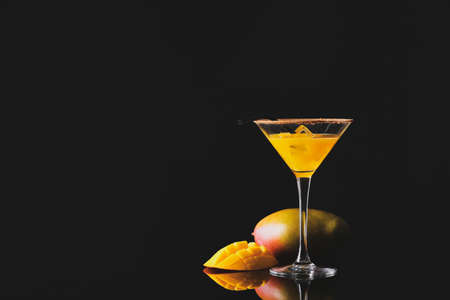 Glass of tasty mango margarita on dark backgroundの写真素材