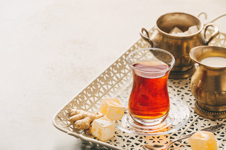 Glass of tasty Turkish tea and delights on light backgroundの写真素材