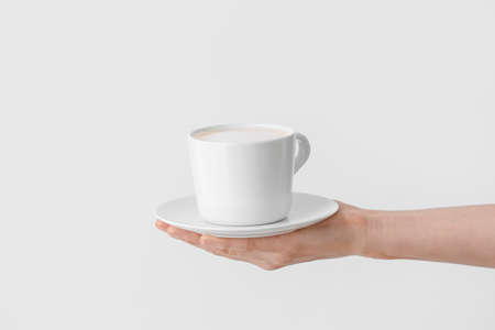 Woman holding cup of tasty latte on white backgroundの写真素材