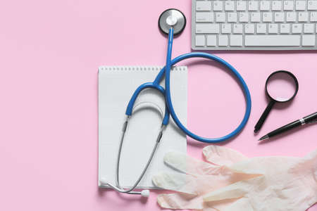 Composition with modern stethoscope and computer keyboard on color backgroundの写真素材