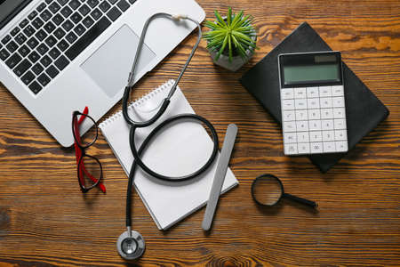 Composition with modern stethoscope and laptop on wooden backgroundの写真素材