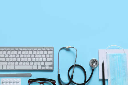 Composition with modern stethoscope and computer keyboard on color backgroundの写真素材