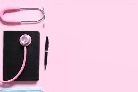 Modern stethoscope, notebook and pen on color backgroundの写真素材