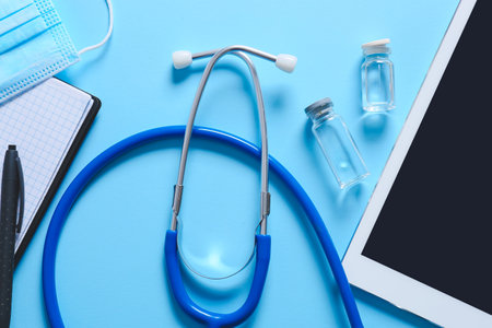 Composition with modern stethoscope and tablet computer on color background, closeupの写真素材
