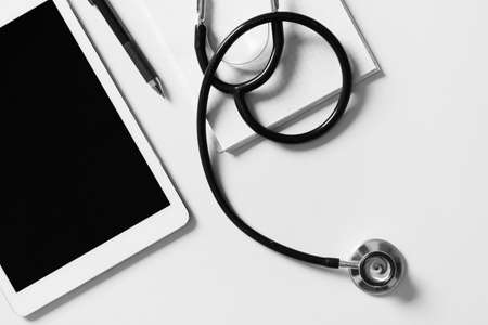 Composition with modern stethoscope and tablet computer on light background, closeupの写真素材