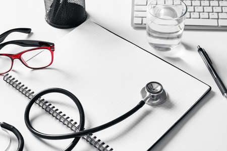 Composition with modern stethoscope and notebook on light background, closeupの写真素材