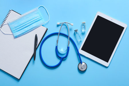 Composition with modern stethoscope and tablet computer on color backgroundの写真素材