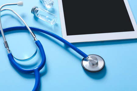 Composition with modern stethoscope and tablet computer on color background, closeupの写真素材