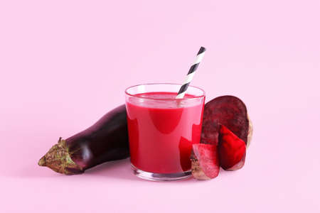 Glass of healthy smoothie with beet and eggplant on color background