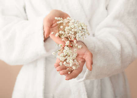 Young woman in bathrobe and with beautiful flowers, closeupの写真素材
