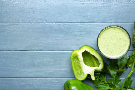 Glass of healthy smoothie with green vegetables on color wooden backgroundの写真素材