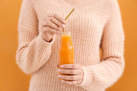 Woman with bottle of healthy smoothie on color background, closeupの写真素材