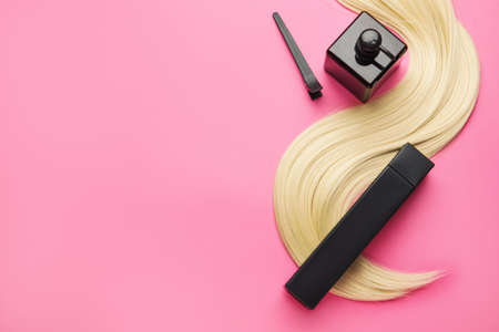 Bottles of shampoo and hair strand on color backgroundの写真素材