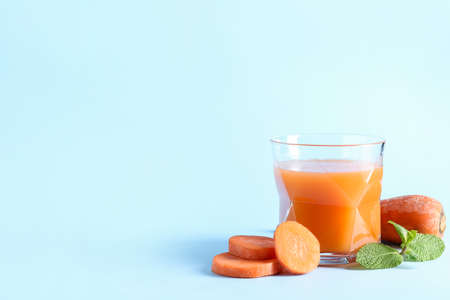Glass of healthy smoothie with carrot on color backgroundの写真素材