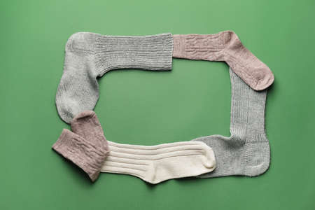Frame made of warm socks on color backgroundの写真素材
