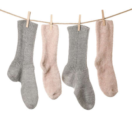 Warm socks hanging on clothes line against white backgroundの写真素材