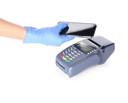 Female hand with mobile phone and payment terminal on white background