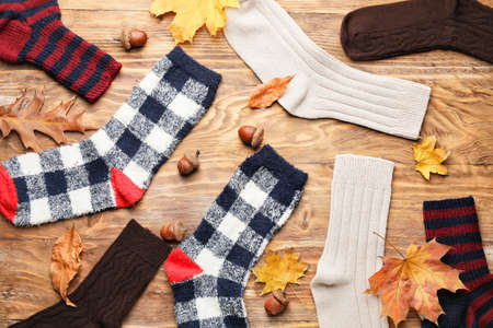 Warm socks and autumn leaves on wooden backgroundの写真素材