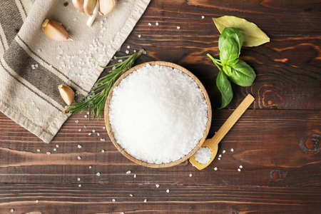 Bowl and spoon with salt on wooden backgroundの写真素材