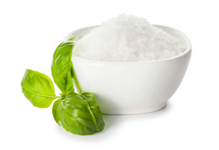 Bowl with salt and basil on white backgroundの写真素材