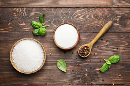 Bowls with salt and peppercorns on wooden backgroundの写真素材