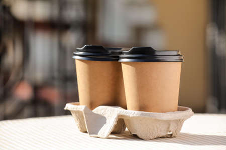 Takeaway cups of tasty latte on table outdoors, closeupの写真素材