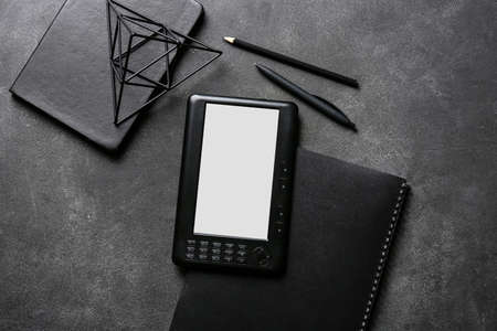 E-reader and notebooks on dark backgroundの写真素材