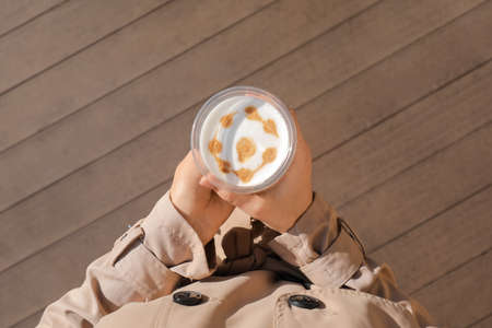 Woman with takeaway cup of tasty latte outdoorsの写真素材
