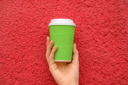Woman with takeaway cup of tasty latte on color backgroundの写真素材