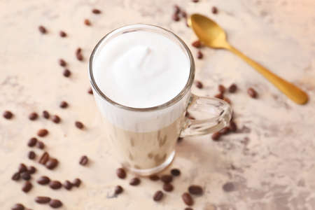 Glass cup of tasty latte on light backgroundの写真素材