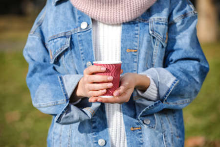 Woman with takeaway cup of tasty latte outdoorsの写真素材