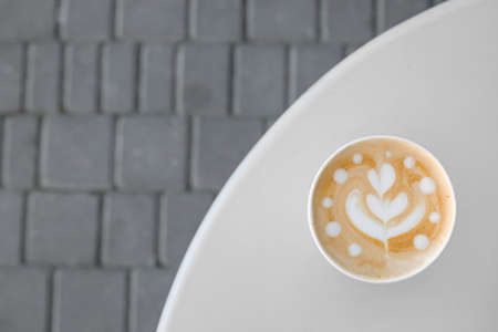 Takeaway cup of tasty latte on table outdoorsの写真素材