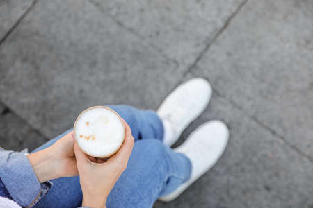Woman with takeaway cup of tasty latte outdoorsの写真素材