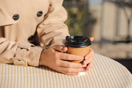 Woman drinking tasty latte outdoors, closeupの写真素材