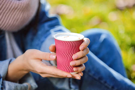 Woman drinking tasty latte outdoors, closeupの写真素材