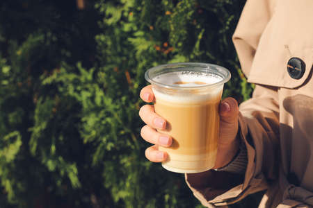 Woman drinking tasty latte outdoors, closeupの写真素材
