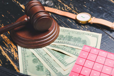 Judge gavel with calculator and money on dark wooden background. Concept of bankruptcyの写真素材