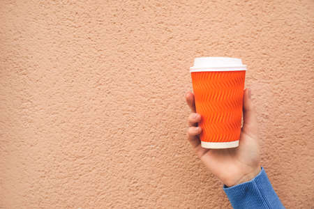 Woman with takeaway cup of tasty latte on color backgroundの写真素材
