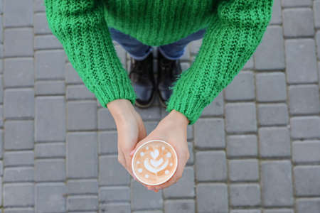 Woman with takeaway cup of tasty latte outdoorsの写真素材
