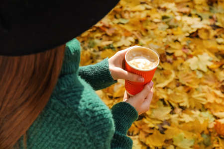 Woman with takeaway cup of tasty latte in parkの写真素材