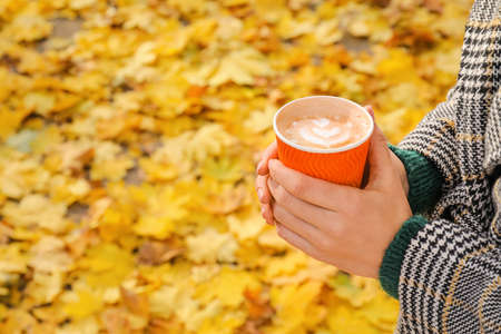 Woman with takeaway cup of tasty latte in parkの写真素材