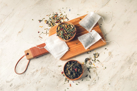 Tea bag and bowls with dry leaves on light backgroundの写真素材