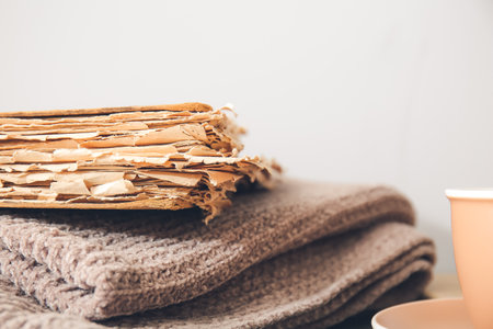 Old book and plaid on table, closeupの写真素材