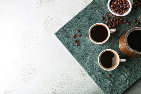 Cups of tasty hot coffee on grunge background