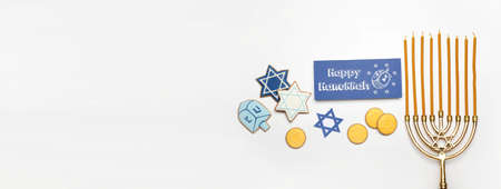 Menorah, tasty cookies and greeting card for Hanukkah on white background with space for textの写真素材