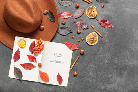Beautiful autumn composition with hat and notebook on dark background