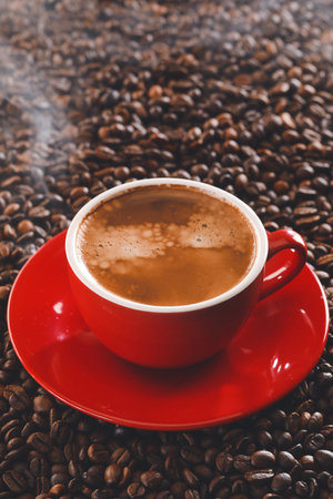 Cup of hot coffee on roasted beansの写真素材